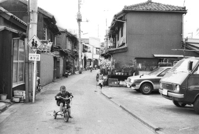 三輪車の子どもが遊ぶ裏通り